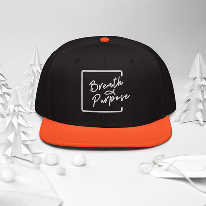 Product mockFront view of black and orange Breath & Purpose snapback hat with embroidered white logo and orange flat visorup