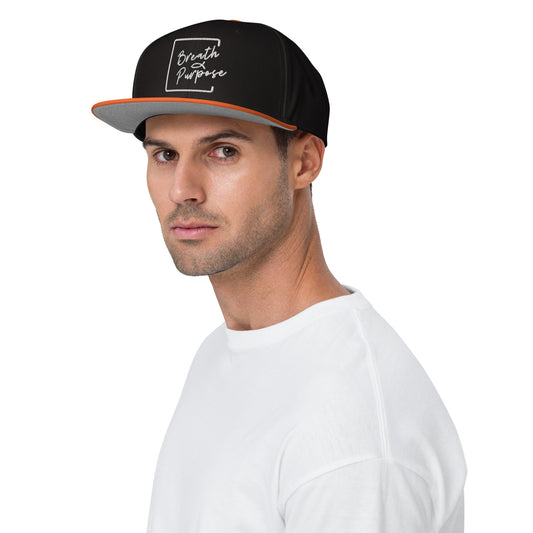 Model wearing black and orange Breath & Purpose embroidered logo snapback hat, front and side view