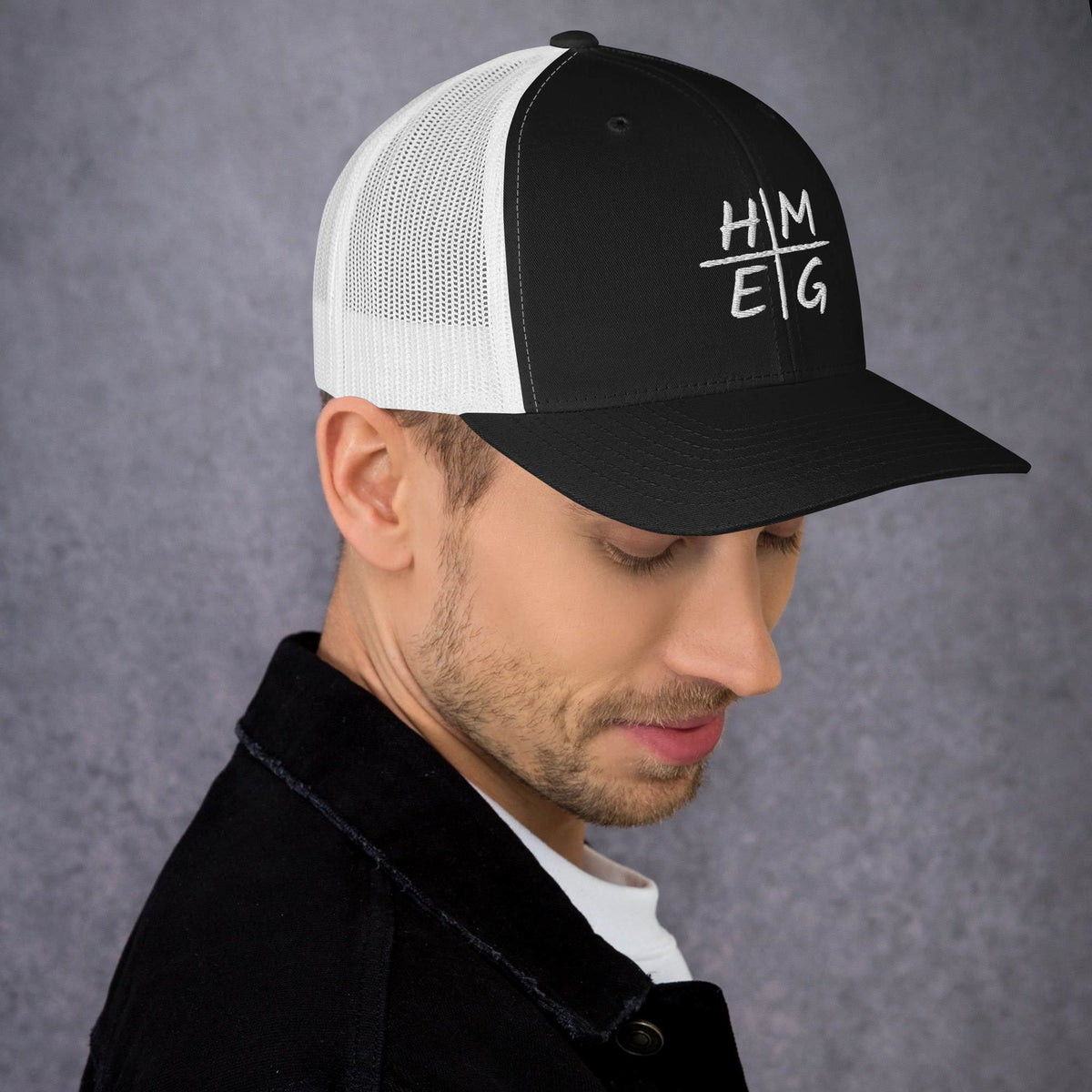 Black and white mesh HMEG Christian trucker hat with embroidered front