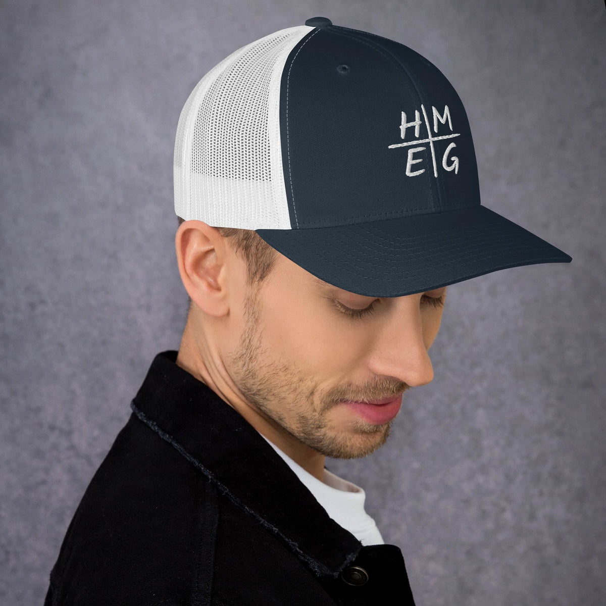 Navy and white mesh HMEG Christian trucker hat with embroidered design