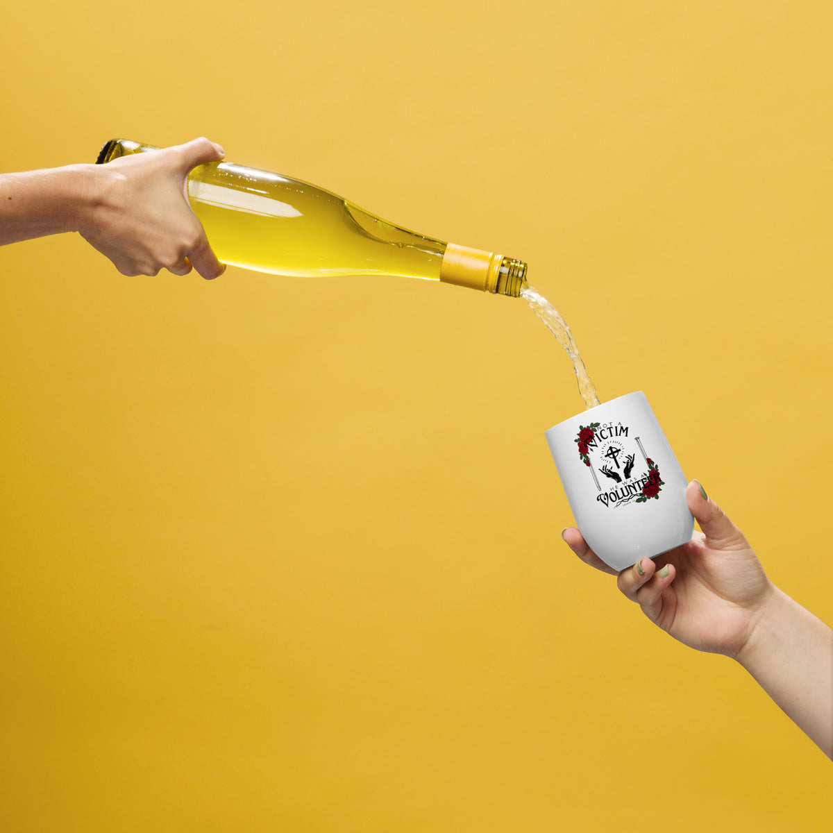 White Not a Victim Christian wine tumbler being passed between two people against a yellow background